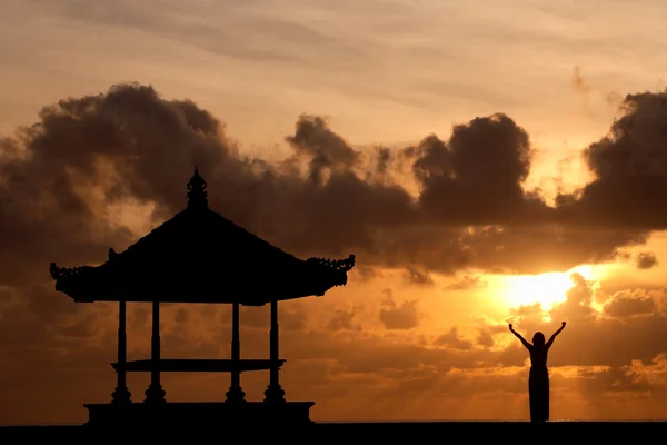 Жінка, піднімаючи руки при сходом сонця — стокове фото