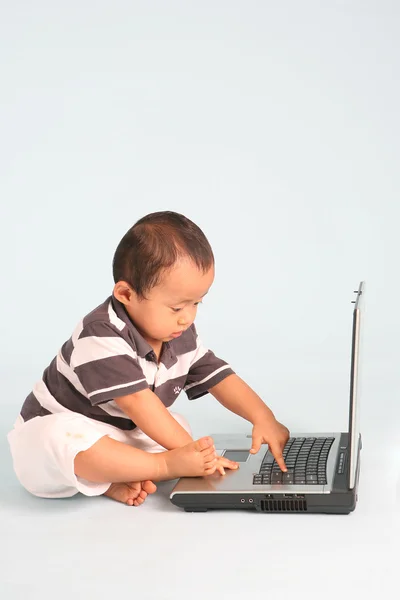 Serioustoddler mit einem laptop — Stockfoto