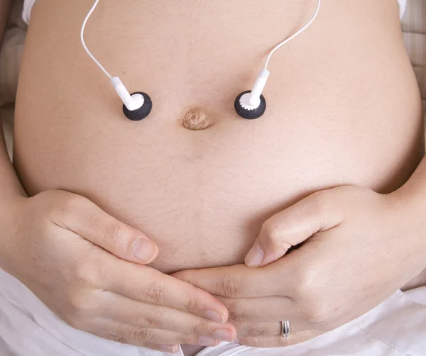 Hamile kadın müzik dinliyor. — Stok fotoğraf