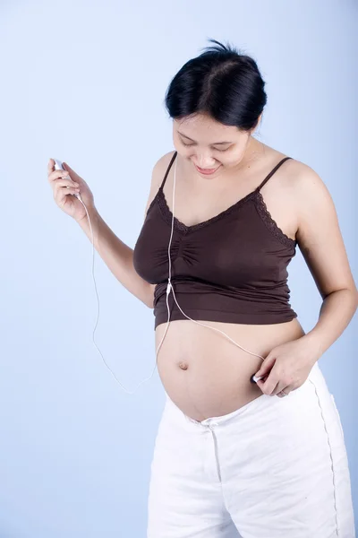 Zwangere vrouw luistert naar muziek — Stockfoto