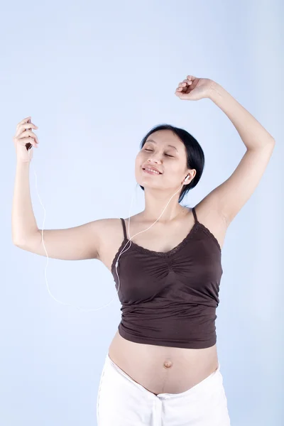 Gravid kvinna lyssnar på musik — Stockfoto