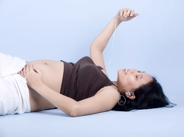 Hamile kadın müzik dinliyor. — Stok fotoğraf