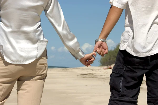 Para trzymająca się za ręce na plaży — Zdjęcie stockowe
