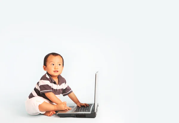 Bir dizüstü bilgisayar kullanarak mutlu yürümeye başlayan çocuk — Stok fotoğraf