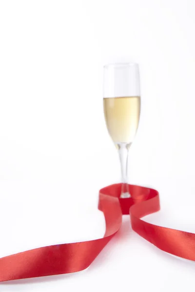 Champagne glass with red ribbon — Stock Photo, Image