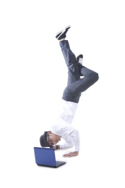 Businessman acrobat while using his laptop clipart