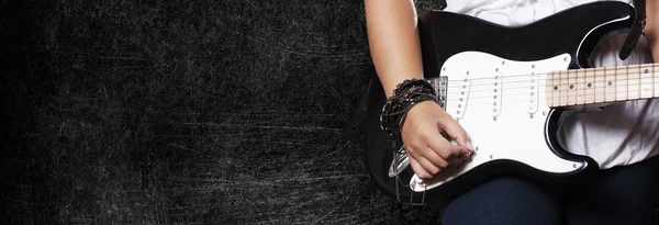 Vértes lány játszik a gitár, a háttér sötét grunge — Stock Fotó