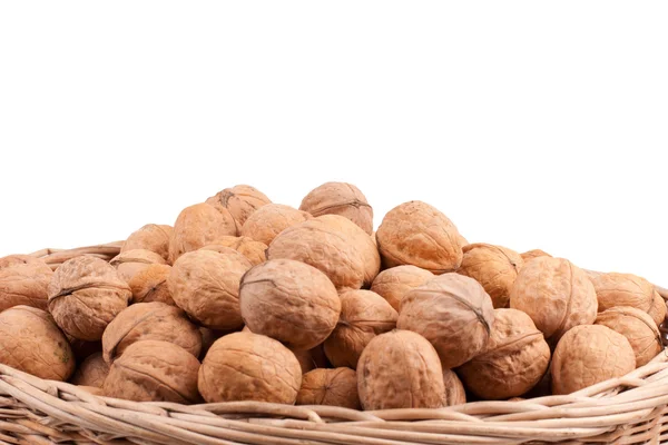 Walnuts in wooden basket on the white background — Stock Photo, Image