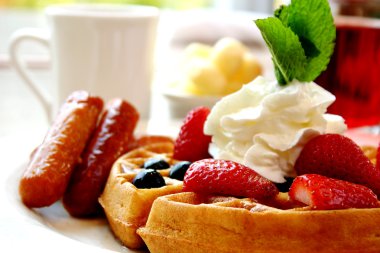 Blueberry waffles with strawberries and sausages clipart