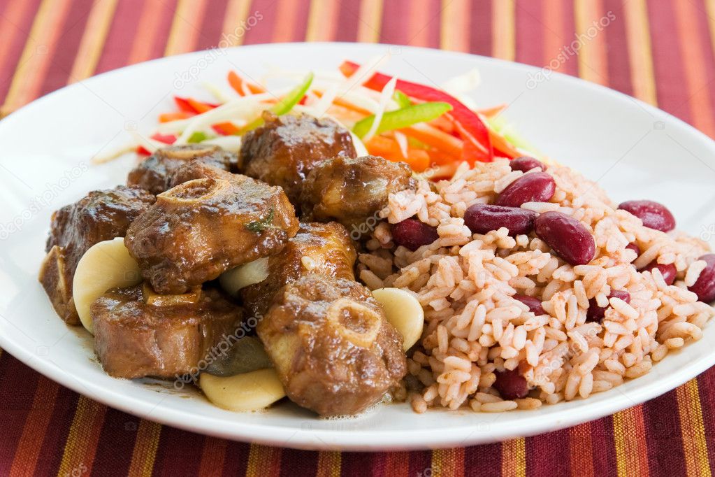 Caribbean style curried Oxtail served with rice mixed with red kidney beans. Dish accompanied with vegetable salad. Shallow DOF.