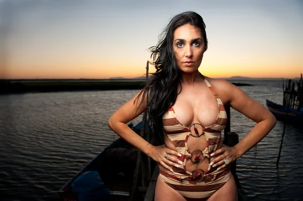 Красивая женщина на закате в гавани — стоковое фото