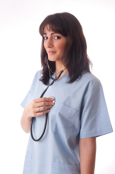 Женщина-врач со стетоскопом слушает свое сердце — стоковое фото