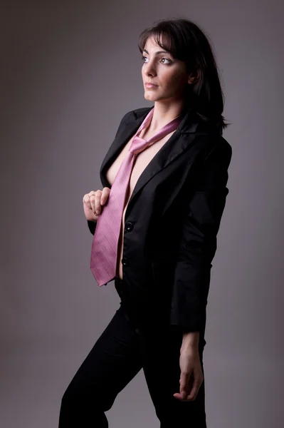 Femme exécutive sensuelle en costume noir et cravate — Photo