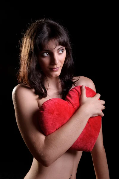 Woman holding a heart shaped pillow — Stock Photo, Image