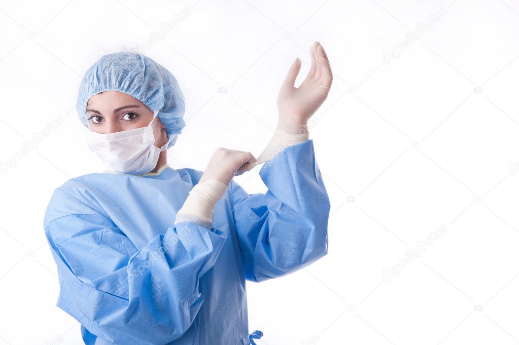 Female surgeon or nurse putting on sterile gloves streatching the rubber gl