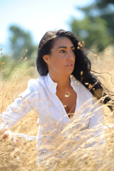 Beautiful woman on a field of straw thinking — Stock Photo, Image