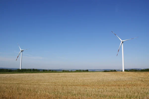 Turbiny wiatrowe na tle błękitnego nieba — Zdjęcie stockowe