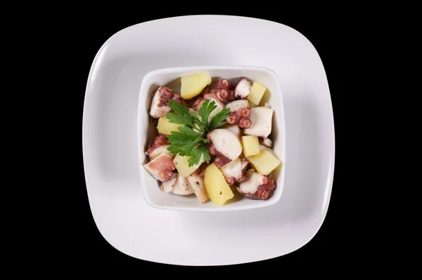 Octopus with potatoes served in a white dish — Stock Photo, Image
