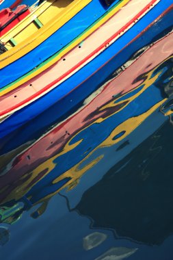 Traditional Maltese fishing boats with reflection