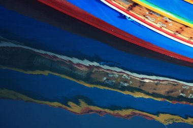 Traditional Maltese fishing boats with reflection