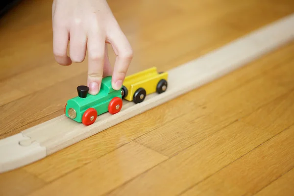 Child hand's playing with a wooden toy train — Stock Photo, Image