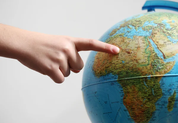 stock image Hand's child pointing on a globe