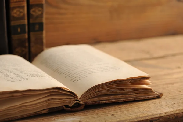 Livro velho aberto em uma mesa de madeira — Fotografia de Stock
