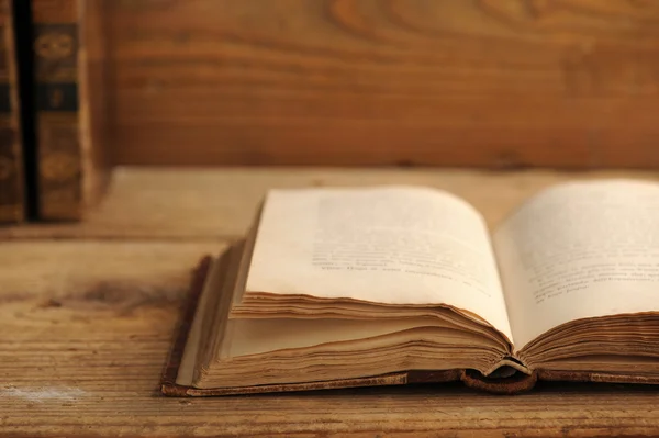 Livro velho aberto em uma mesa de madeira — Fotografia de Stock
