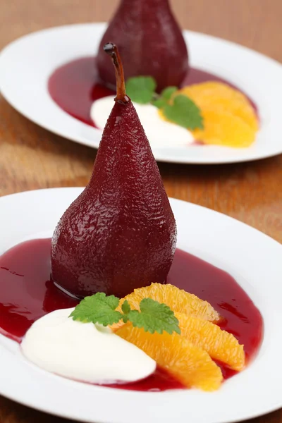 Gepocheerde peren in rode wijn met sinaasappels en crème fraiche — Stockfoto
