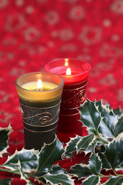 Kerzen und Stechpalme auf weihnachtlichem Hintergrund — Stockfoto