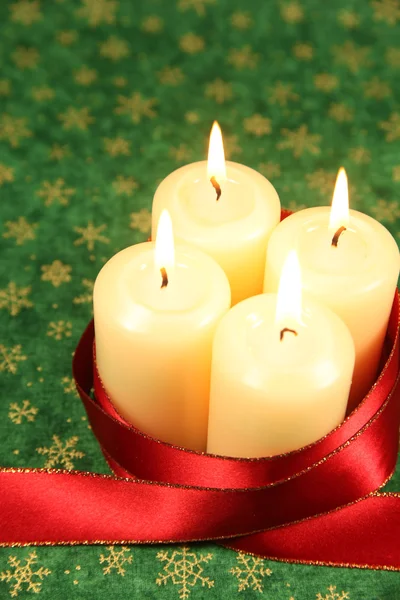 Свечи с ленточкой на рождественском фоне — стоковое фото