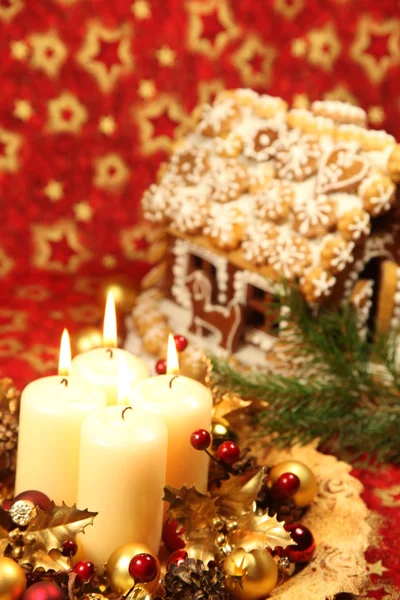 Kerstdecoratie met kaarsen en peperkoek huis — Stockfoto