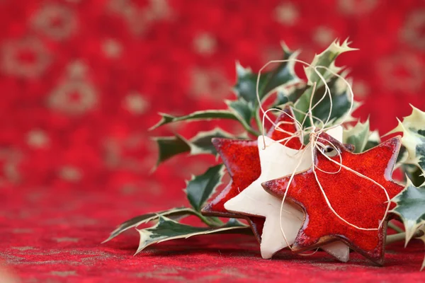 Stars and holly twigs on Christmas background — Stock Photo, Image