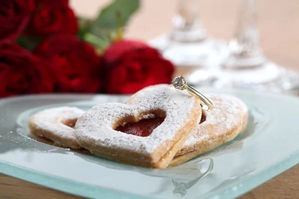 Gold engagement ring and shortbread hearts — Stock Photo, Image