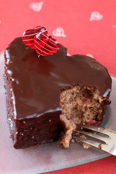 Pastel de chocolate en forma de corazón con un bocado —  Fotos de Stock