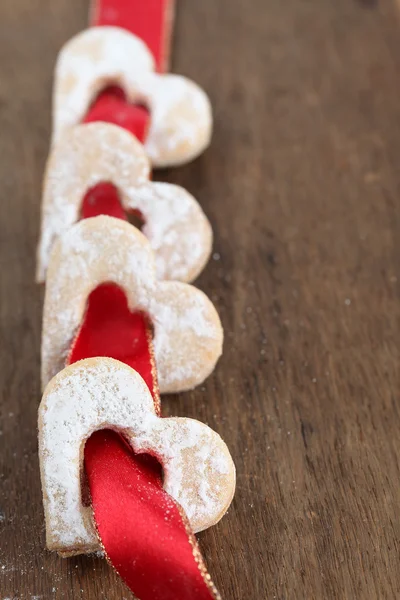 Red ribbon with shortbread hearts — Stock Photo, Image