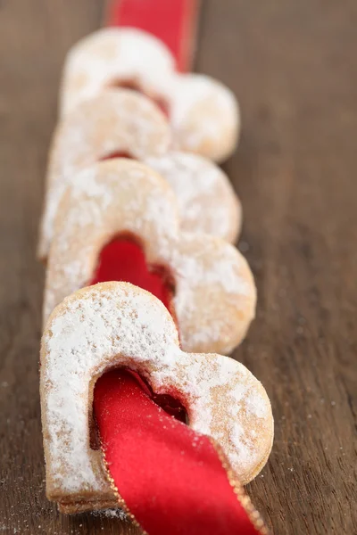Red ribbon with shortbread hearts — Stock Photo, Image
