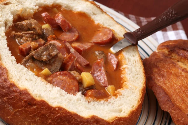 Zupa gulaszowa w misce chleb — Zdjęcie stockowe
