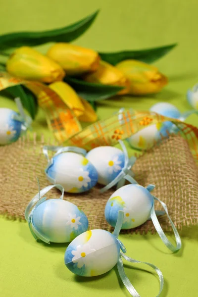 Ovos de Páscoa azuis e tulipas amarelas — Fotografia de Stock