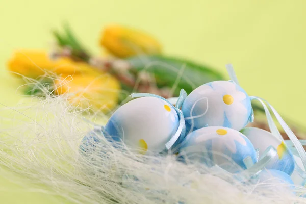Blue Easter eggs and yellow tulips — Stock Photo, Image