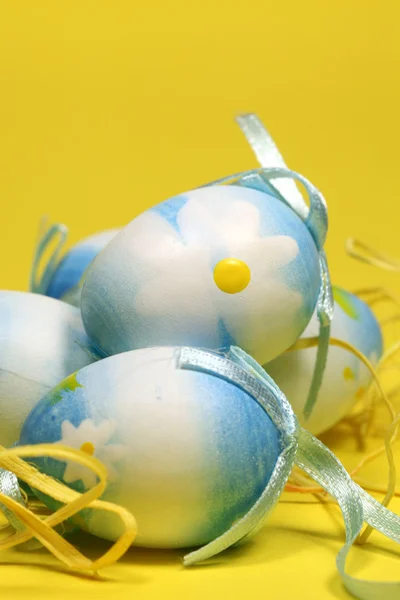 Ovos de Páscoa azul no fundo amarelo — Fotografia de Stock