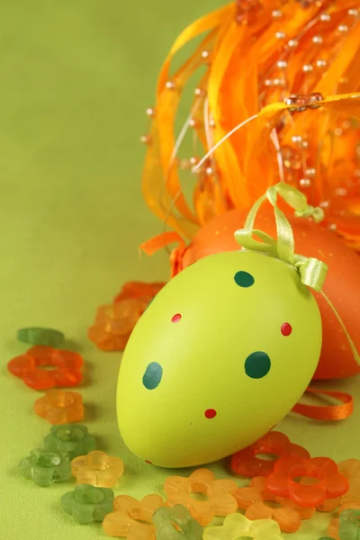 A virágok és a szalag zöld és narancs húsvéti tojás — Stock Fotó
