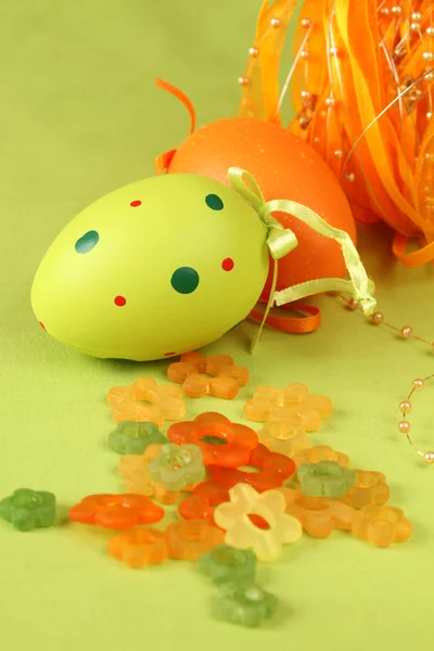 Grüne und orangefarbene Ostereier mit Blumen und Schleife — Stockfoto