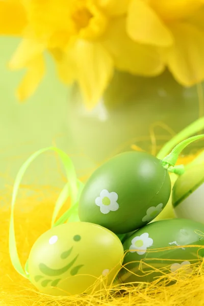 Green Easter eggs and daffodils — Stock Photo, Image