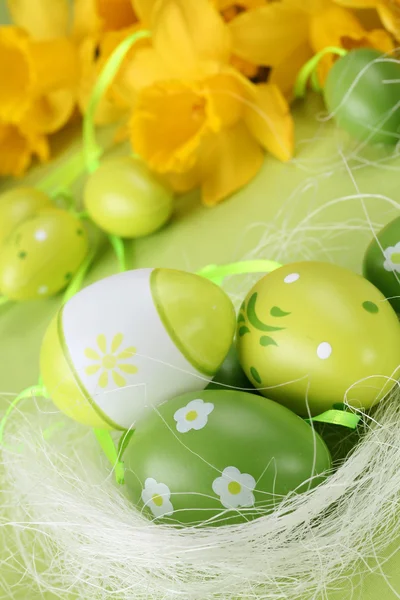 Ovos de Páscoa verdes e narcisos amarelos — Fotografia de Stock