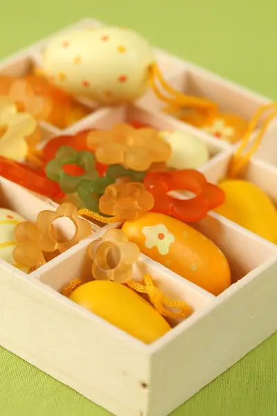 Gula påskägg och blommor i en låda — Stockfoto