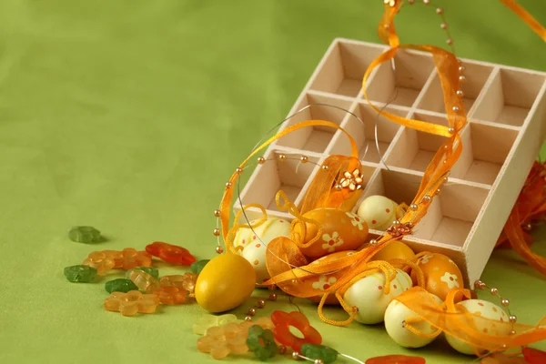 Uova di Pasqua gialle con scatola, fiori e nastro — Foto Stock