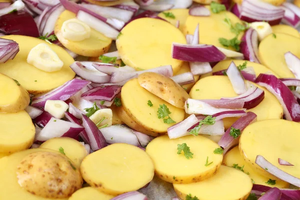 Ruwe aardappelen met rode ui, knoflook en peterselie — Stockfoto