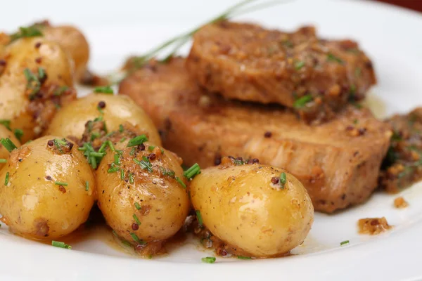 Baby aardappelen met geroosterd varkensvlees — Stockfoto