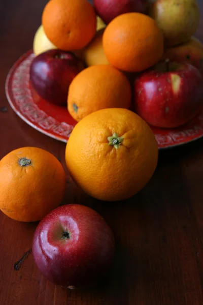Jabłka i pomarańcze na talerzu — Zdjęcie stockowe